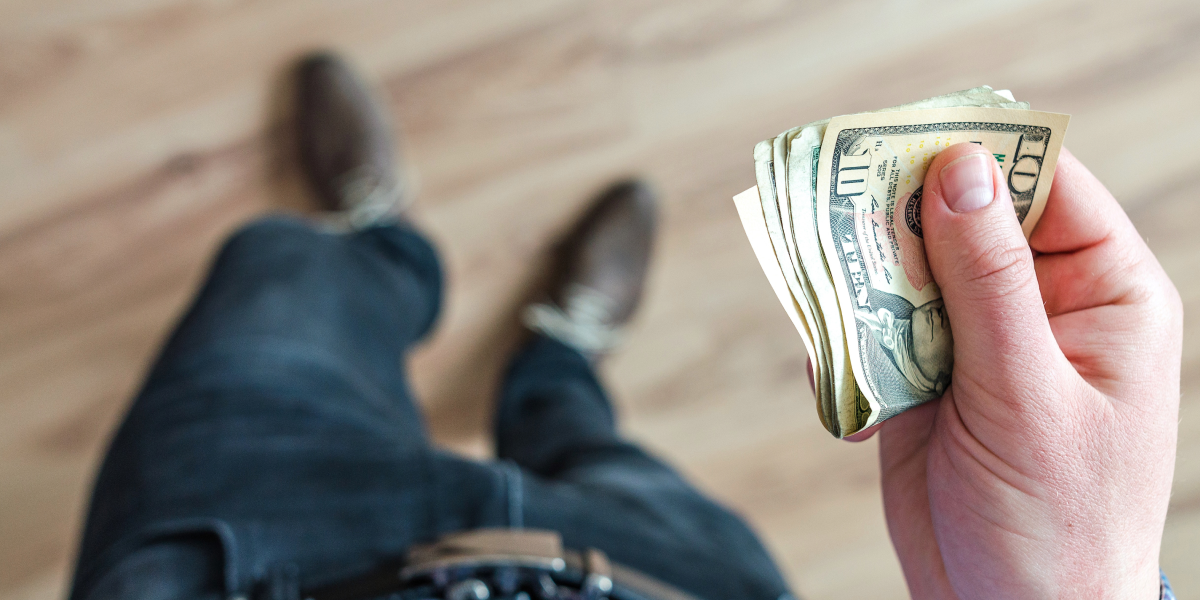 A man holding a stack of cash